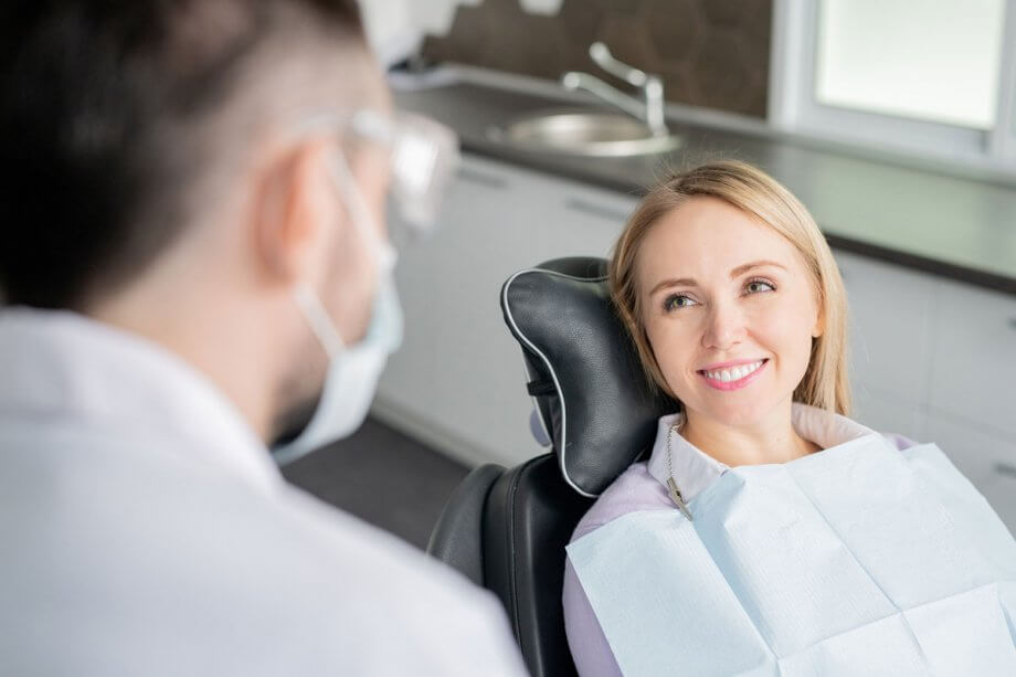 woman smiles at dentist from dental chair