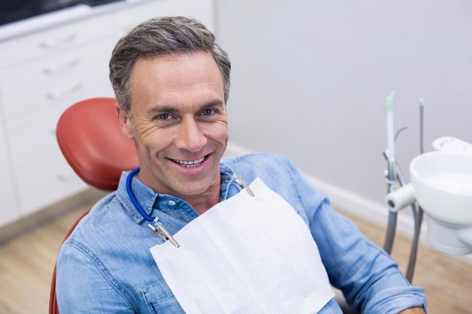 a man smiles in a dental chair