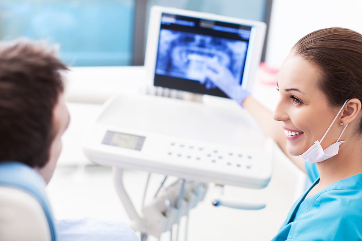 dentist showing patient a digital image on a screen